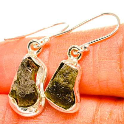 Close-up 925 silver Czech Moldavite hook earrings with textured green stone drops