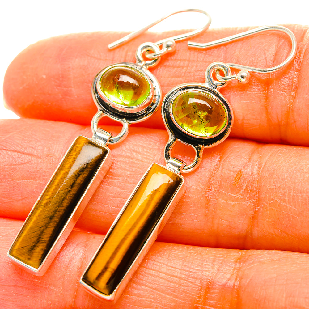 Close-up: 925 sterling silver earrings with green peridot rounds and tiger-eye gold bar drops