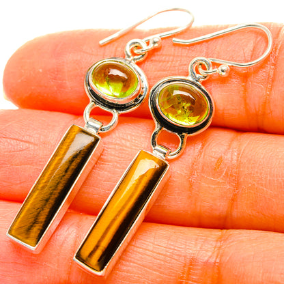 Close-up: 925 sterling silver earrings with green peridot rounds and tiger-eye gold bar drops