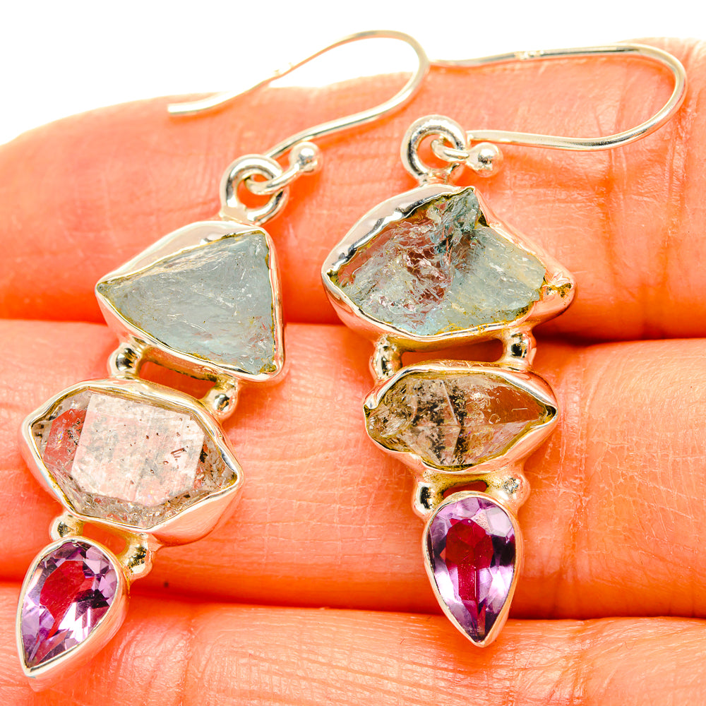 Gemstone drop earrings with blue-green and clear stones, plus purple teardrop accents