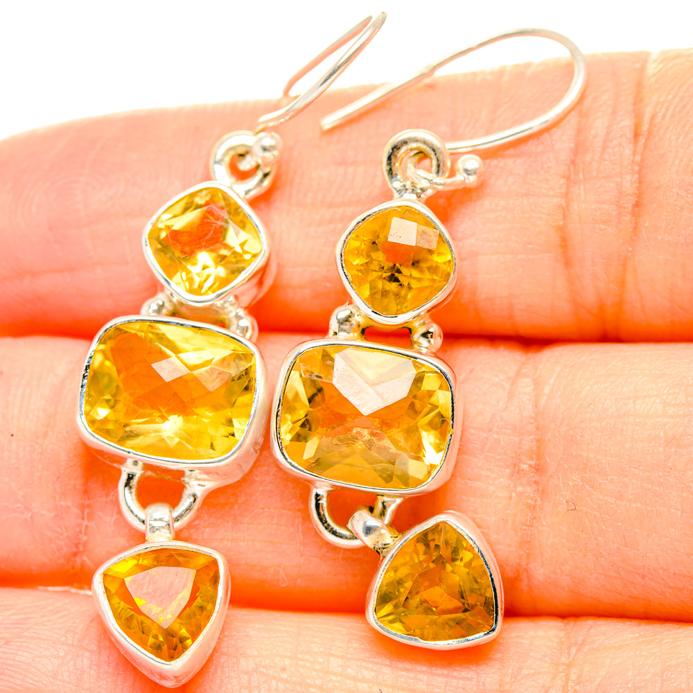 925 sterling silver citrine drop earrings with faceted yellow stones, close-up on hand