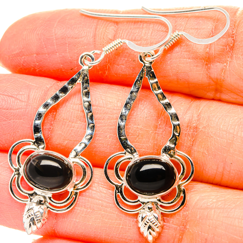 Silver drop earrings with black oval onyx-style stone and decorative teardrop filigree
