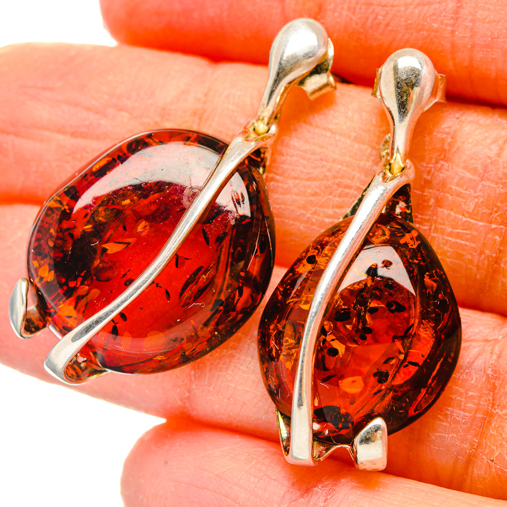 Amber teardrop earrings with 925 sterling silver hooks and gold-toned bezel, close-up