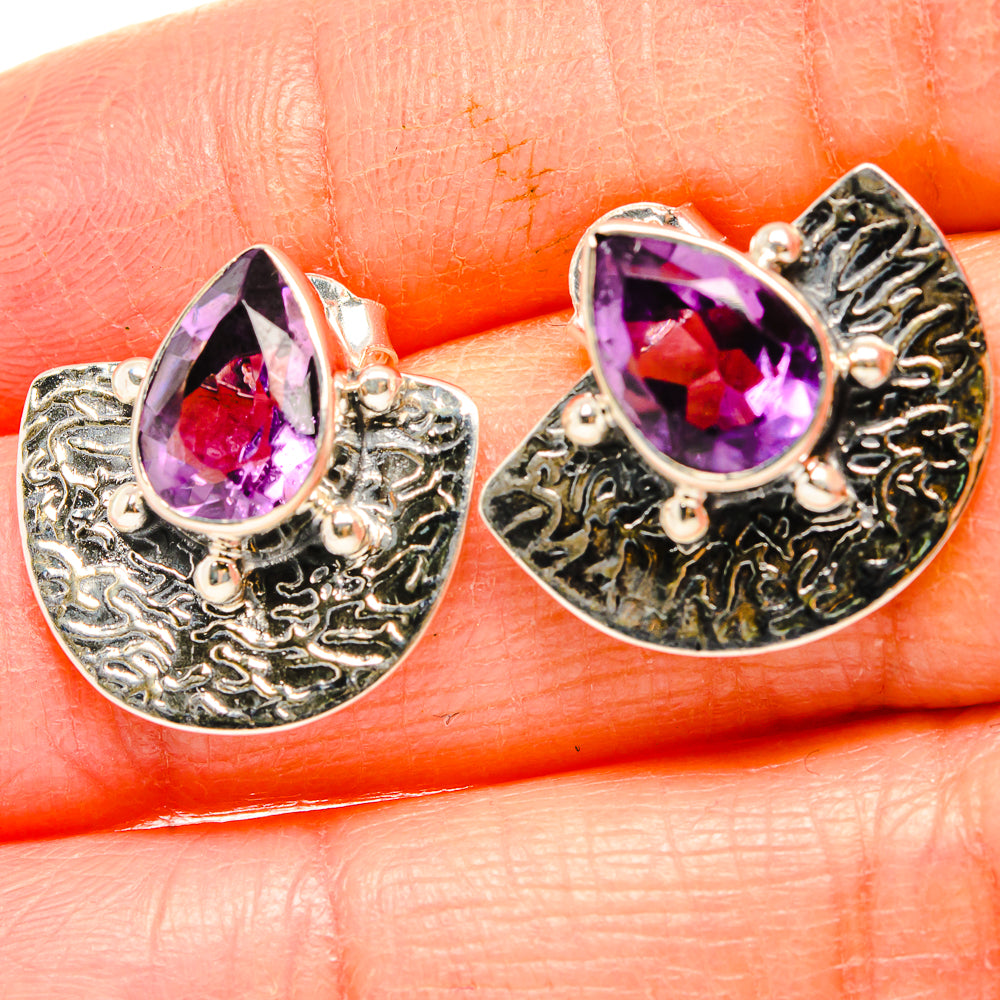 Amethyst teardrop earrings with faceted purple stones and textured silver settings