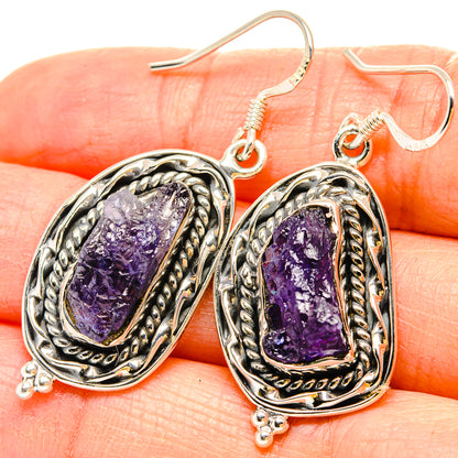 Close-up of sterling silver tanzanite drop earrings with rough purple stone texture