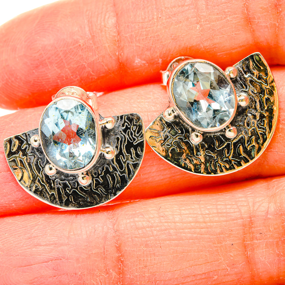 Round blue topaz stud earrings with ornate silver swirl settings