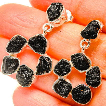 Sterling silver tektite-style drop earrings with textured black stones, close-up