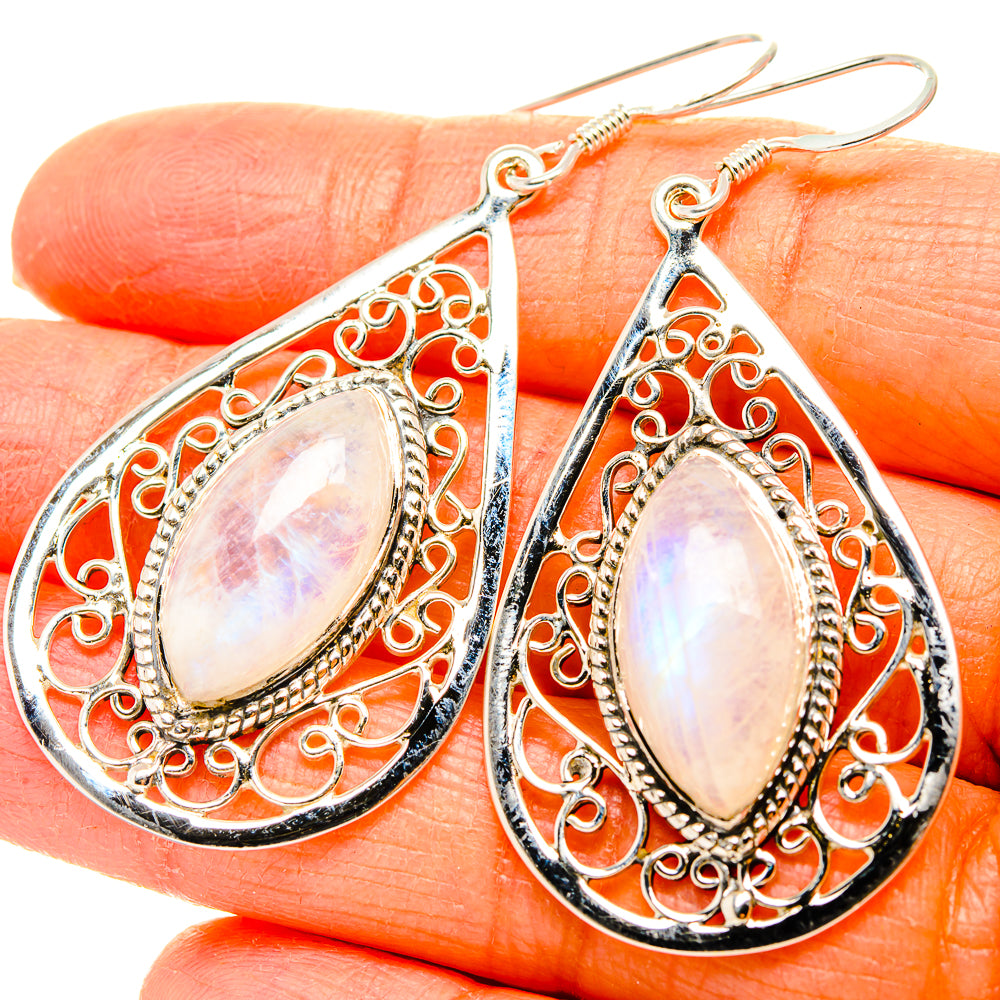 Teardrop moonstone earrings with ornate silver filigree and dangling hooks