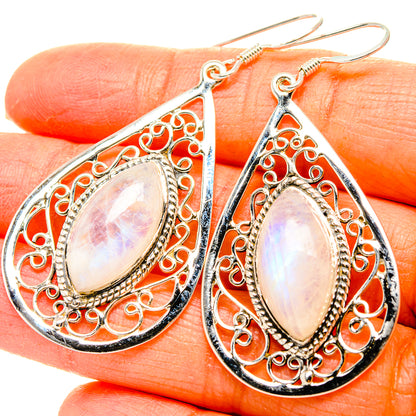 Teardrop moonstone earrings with ornate silver filigree and dangling hooks