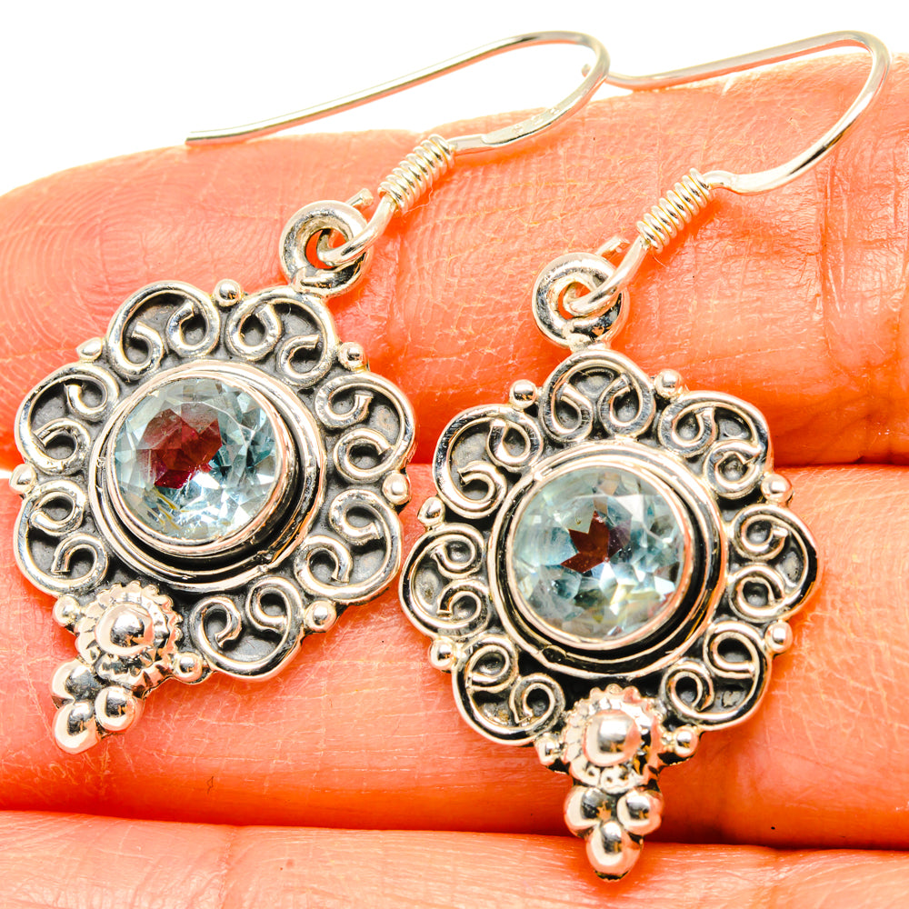 Sterling silver blue topaz filigree drop earrings, round light-blue gemstone, close-up