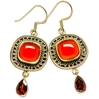 Gold-tone drop earrings with red round cabochons, detailed frame, and red teardrop charms