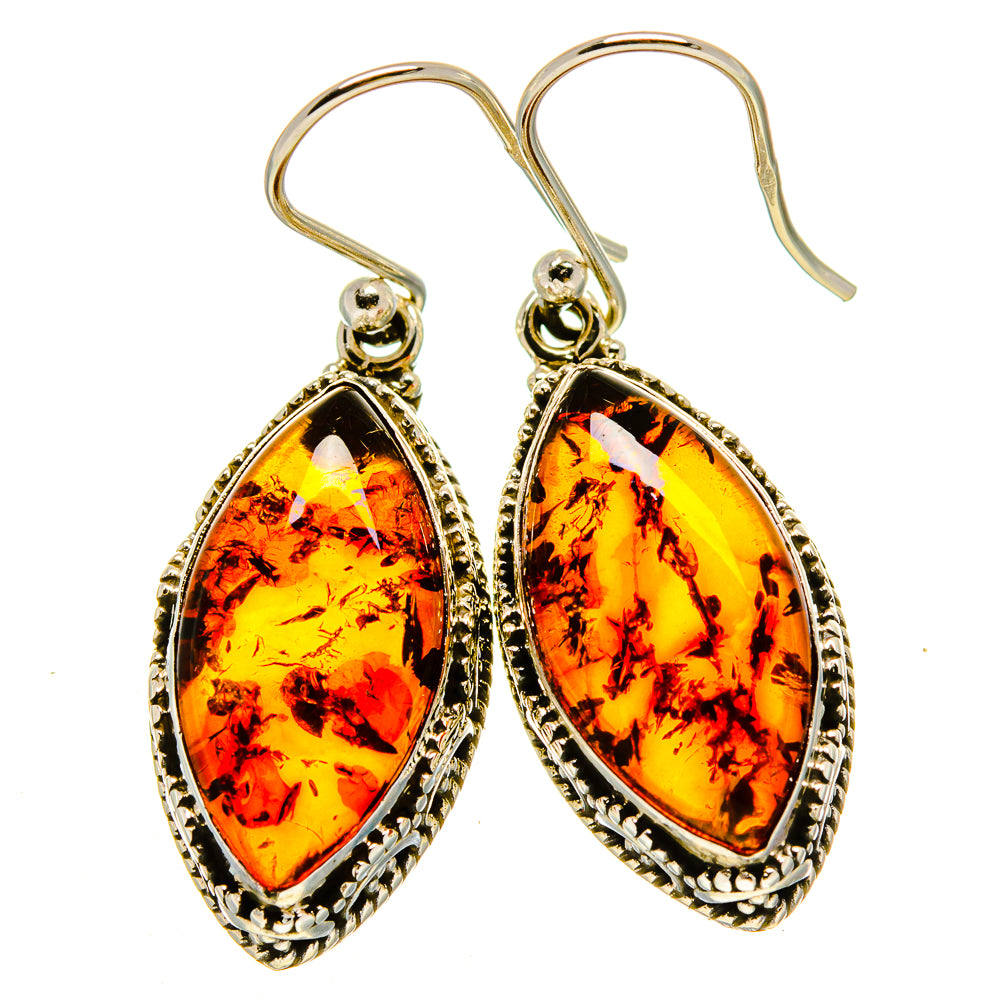 Pair of amber teardrop earrings with ornate silver border and fishhook closures