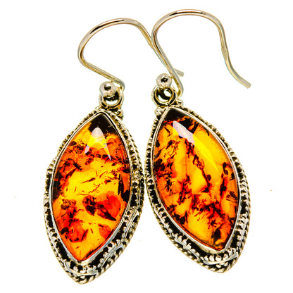 Pair of amber teardrop earrings with ornate silver border and fishhook closures
