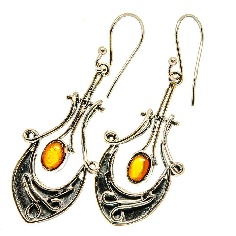Amber drop earrings in silver-tone with ornate scrollwork and yellow-orange cabochons
