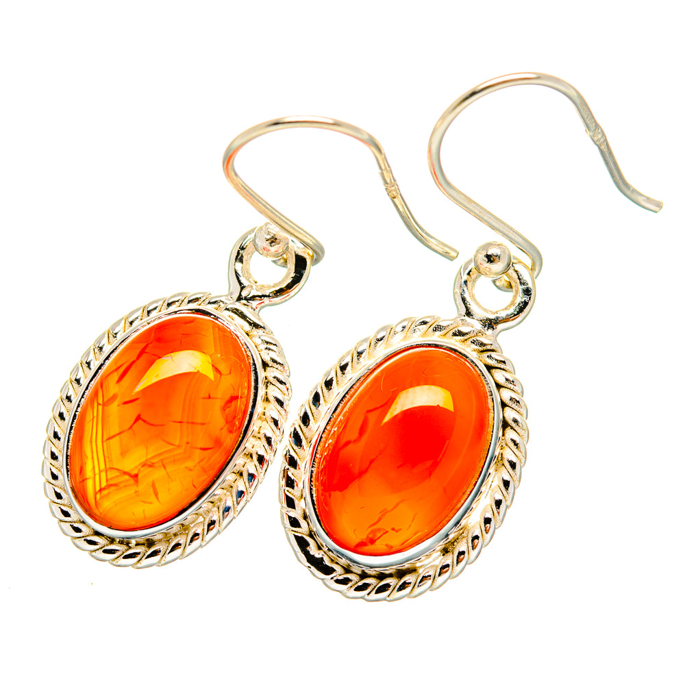 Oval orange carnelian drop earrings with ornate silver bezel and curved hook