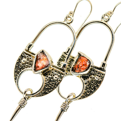 Sterling silver hoop earrings with textured bands, rough orange-red garnet centers, spikes