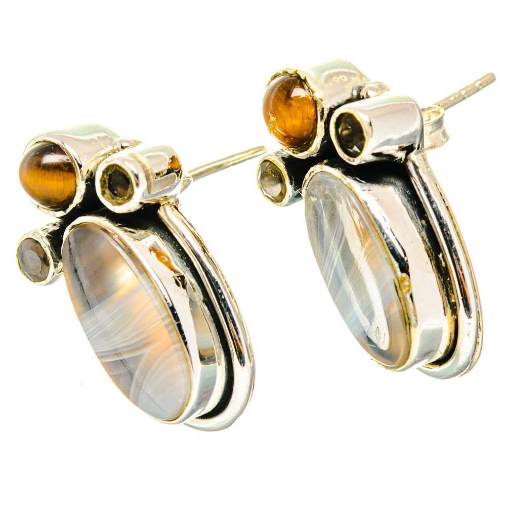 Sterling silver earrings with amber sphere studs and long oval striped gemstone drops.