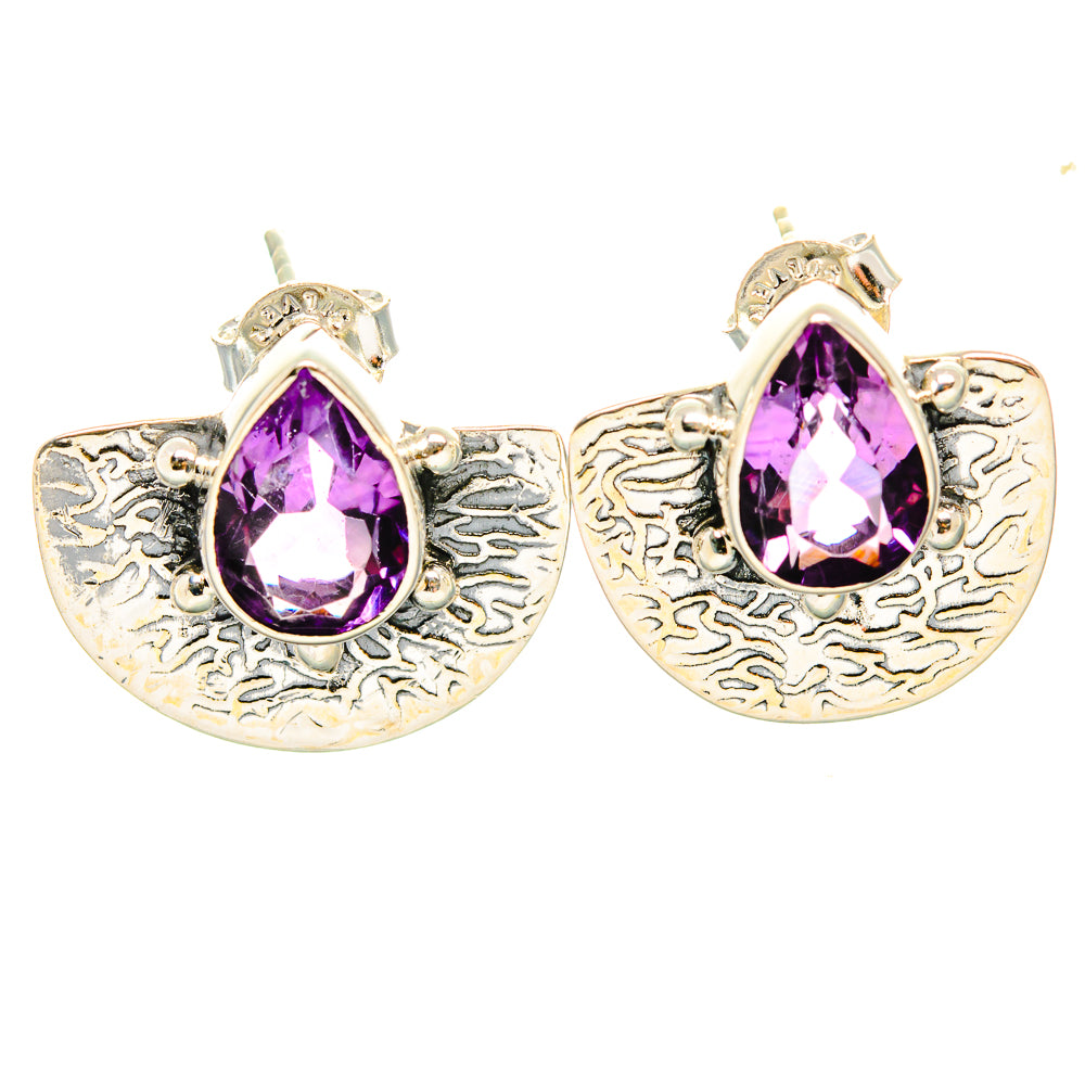 Amethyst drop earrings with faceted pear-shaped purple stones and ornate silver finish