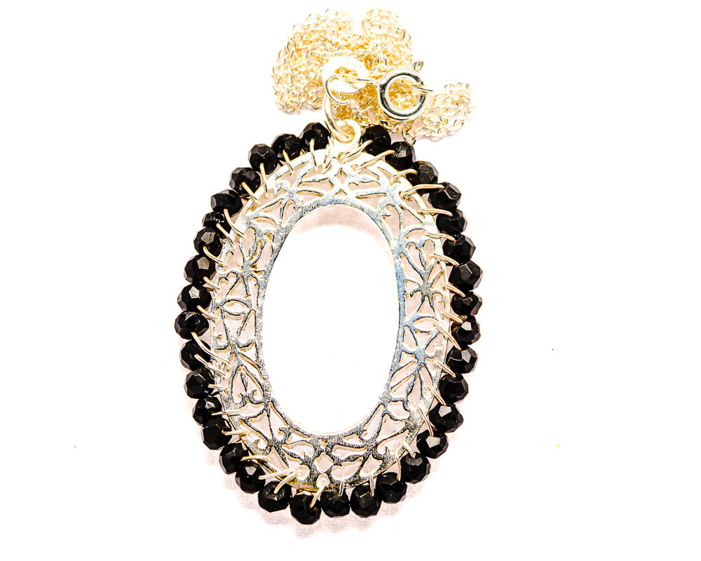 Sterling silver onyx-style oval pendant with black gemstone halo and ornate frame