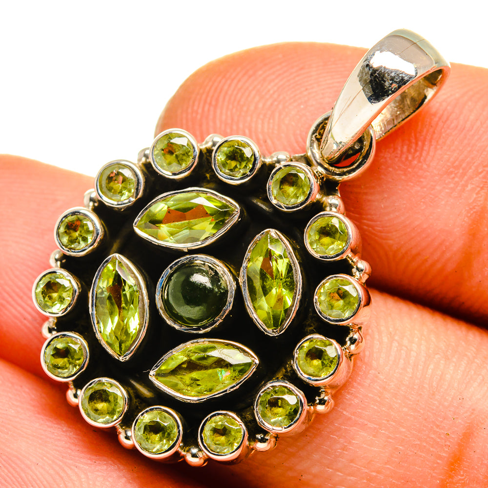 Close-up green gemstone pendant with round and oval stones, gold-tone bezel, silver bail