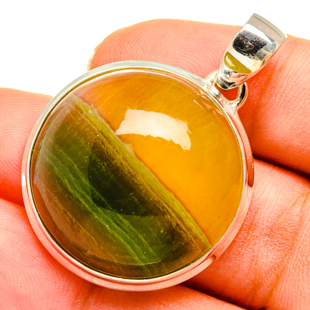 Round fluorite pendant in sterling silver bezel with yellow-green gemstone and bail