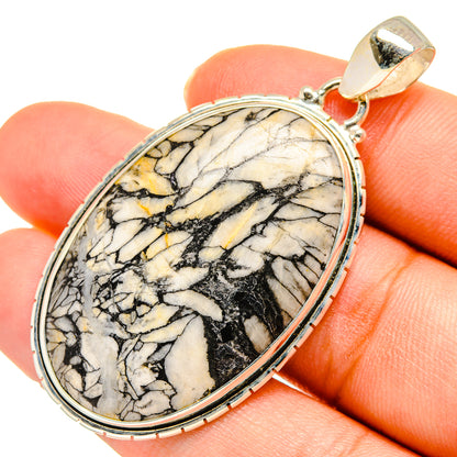 Jasper pendant oval cabochon, close on black and cream veining, silver frame and gold bail