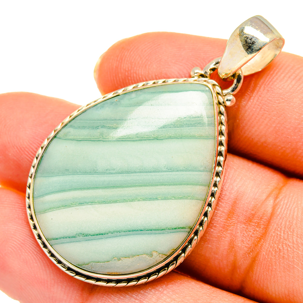 Ocean jasper teardrop pendant on fingers, green striped stone in 925 sterling silver