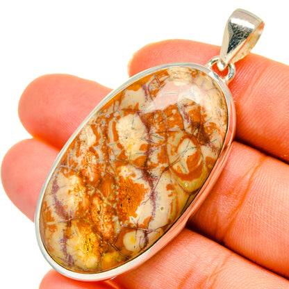Close-up oval poppy jasper pendant in sterling silver bezel, orange, cream, and marbled veins