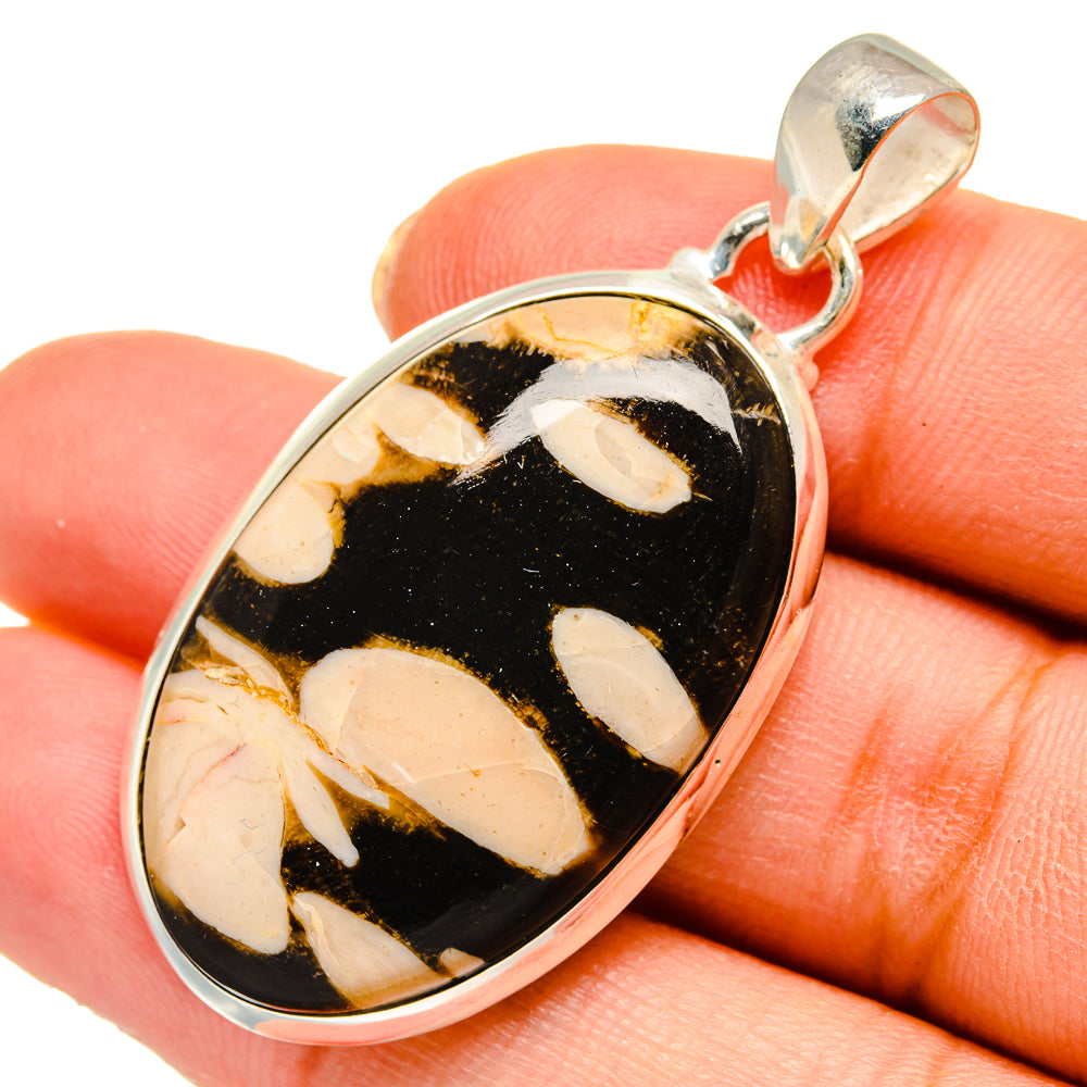 Oval jasper pendant in sterling silver bezel with black, gold, and cream marbled pattern