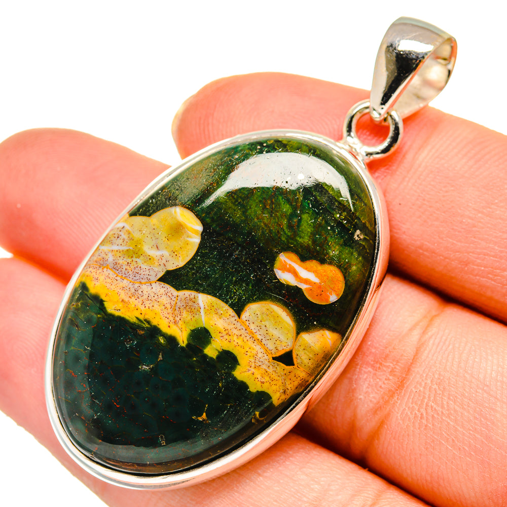 Oval ocean jasper pendant with green-yellow stone and silver bail on top