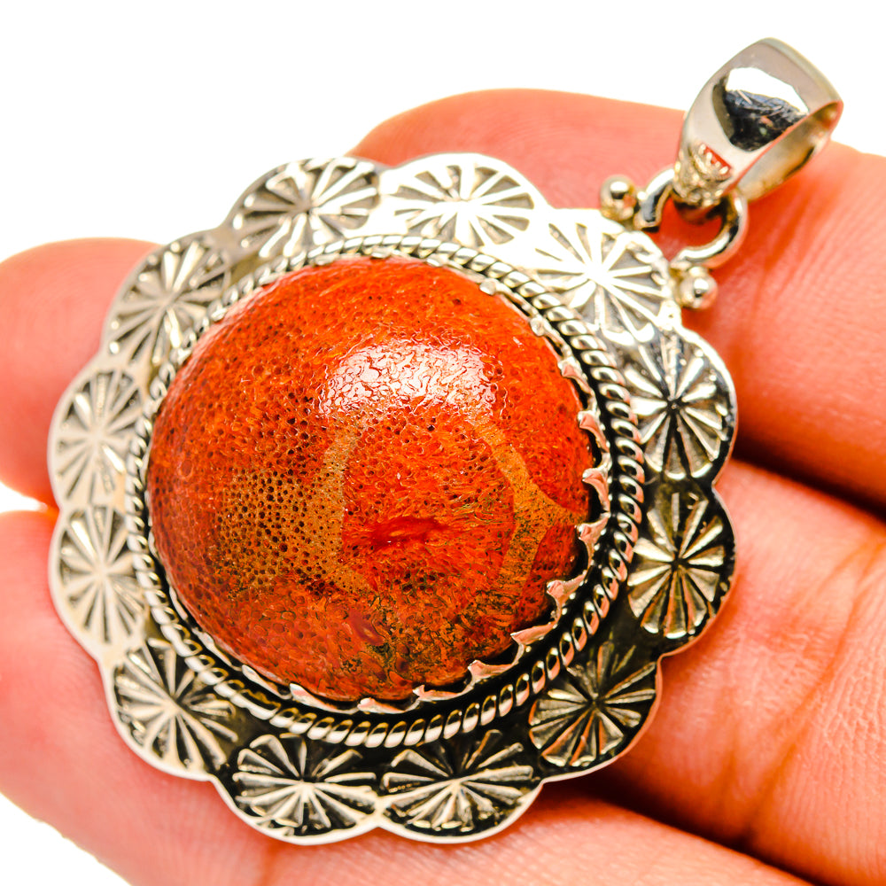 Sterling silver pendant with orange sponge coral cabochon, textured outer sunburst details