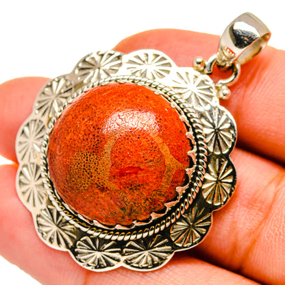 Sterling silver pendant with orange sponge coral cabochon, textured outer sunburst details