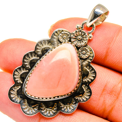 Pink opal pendant closeup on ornate silver-tone setting with top loop bail
