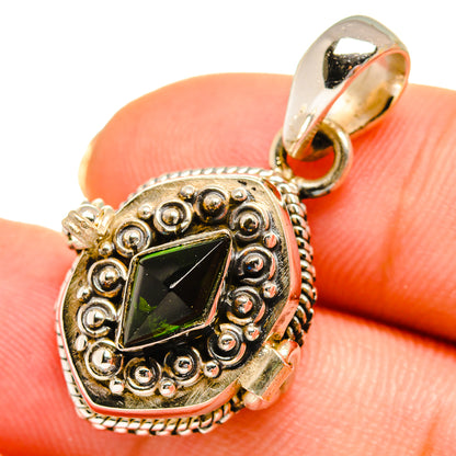 Close-up of ornate green gemstone pendant with textured bezel and round bail ring