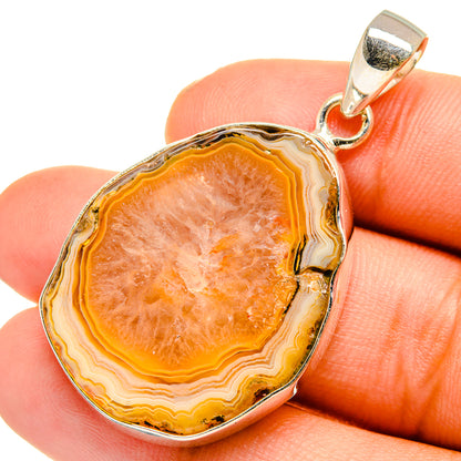 Yellow geode pendant in silver setting, orange banded geode on finger