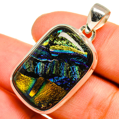 Dichroic glass pendant close-up: iridescent blue, gold, and black cabochon with silver bail