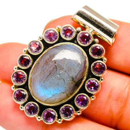 Round gold-tone pendant close-up with iridescent labradorite center and purple amethyst stones
