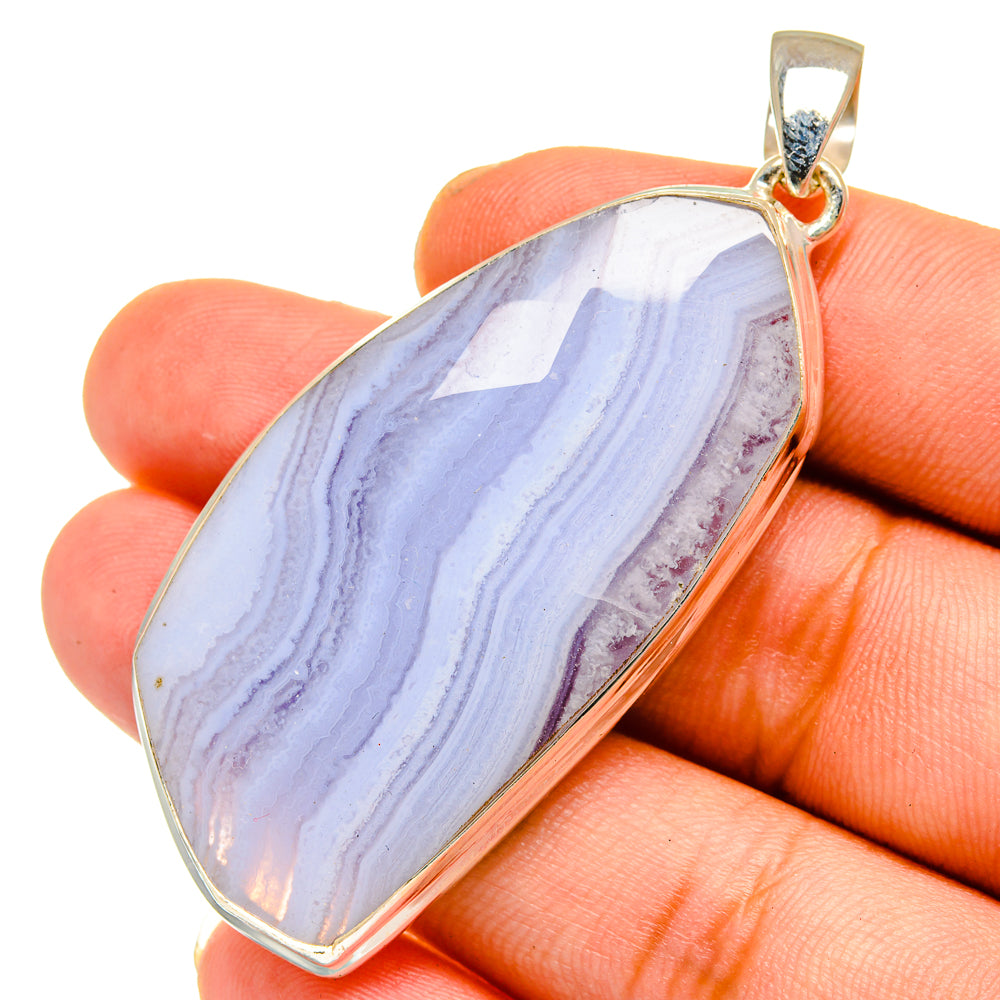 Blue lace agate teardrop pendant in sterling silver with gold-tone bail, close-up