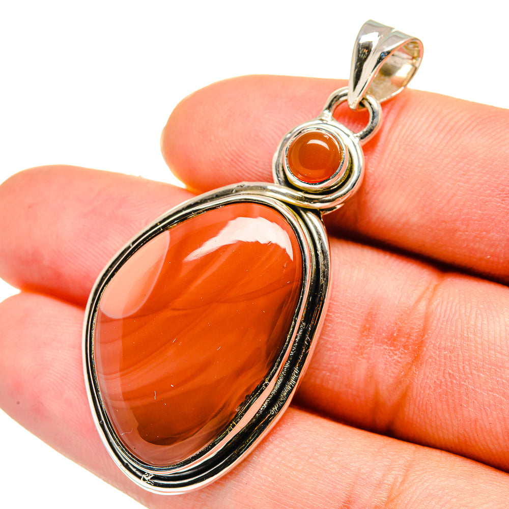 Sterling silver pendant with oval orange carnelian and small imperial jasper accents.