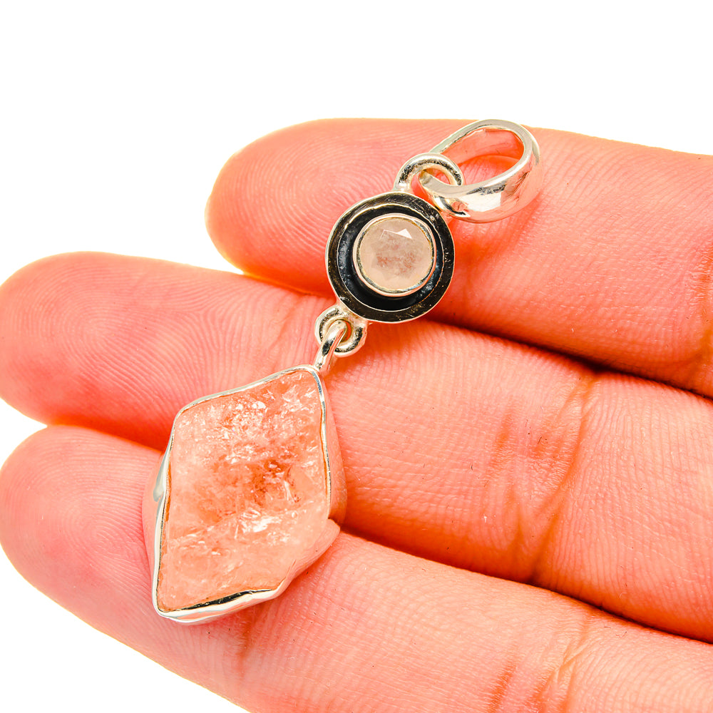 Rough rose quartz pendant with sterling silver bezel, shown in hand