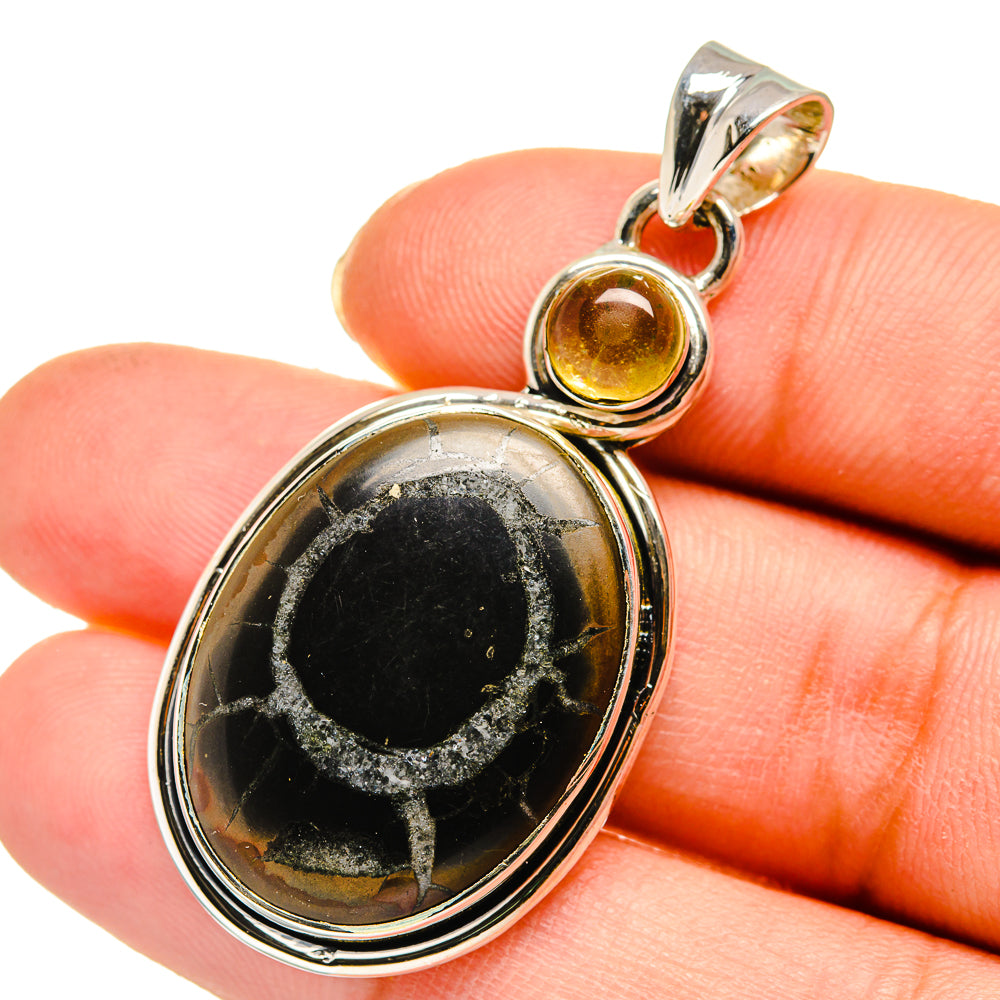 Septarian geode pendant with oval dark stone and small citrine-toned accent, silver bail