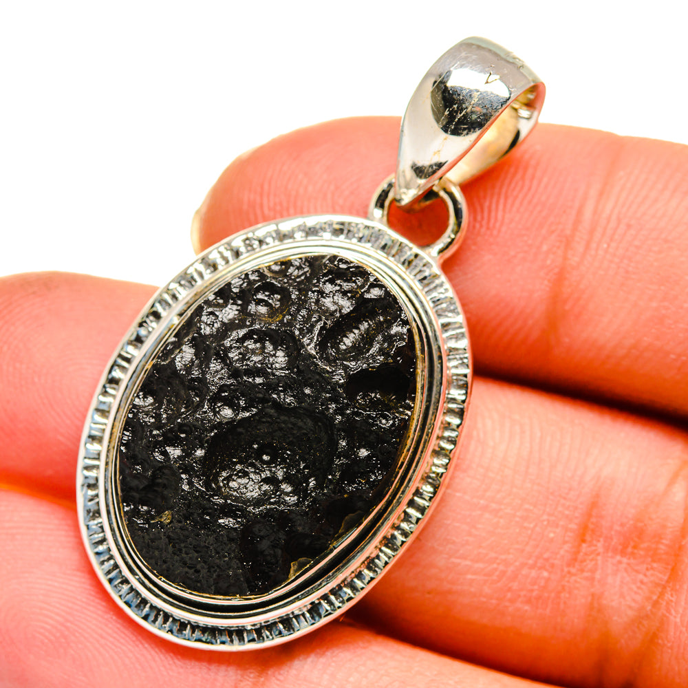 Oval sterling silver tektite pendant with black and gold flecked stone bezel setting