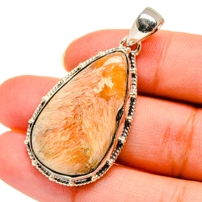 Scolecite pendant close-up: teardrop orange stone set in textured sterling silver