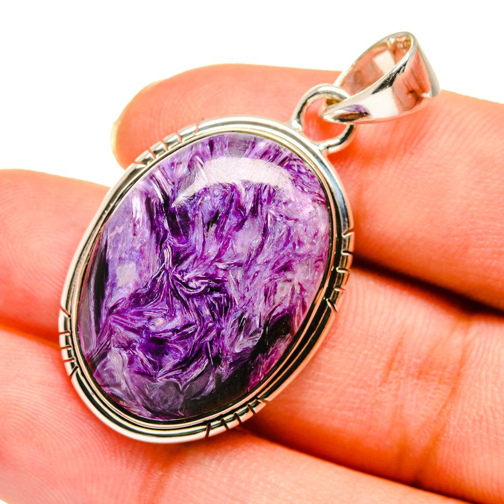 Oval charoite pendant with purple gemstone in silver bezel, close-up detail