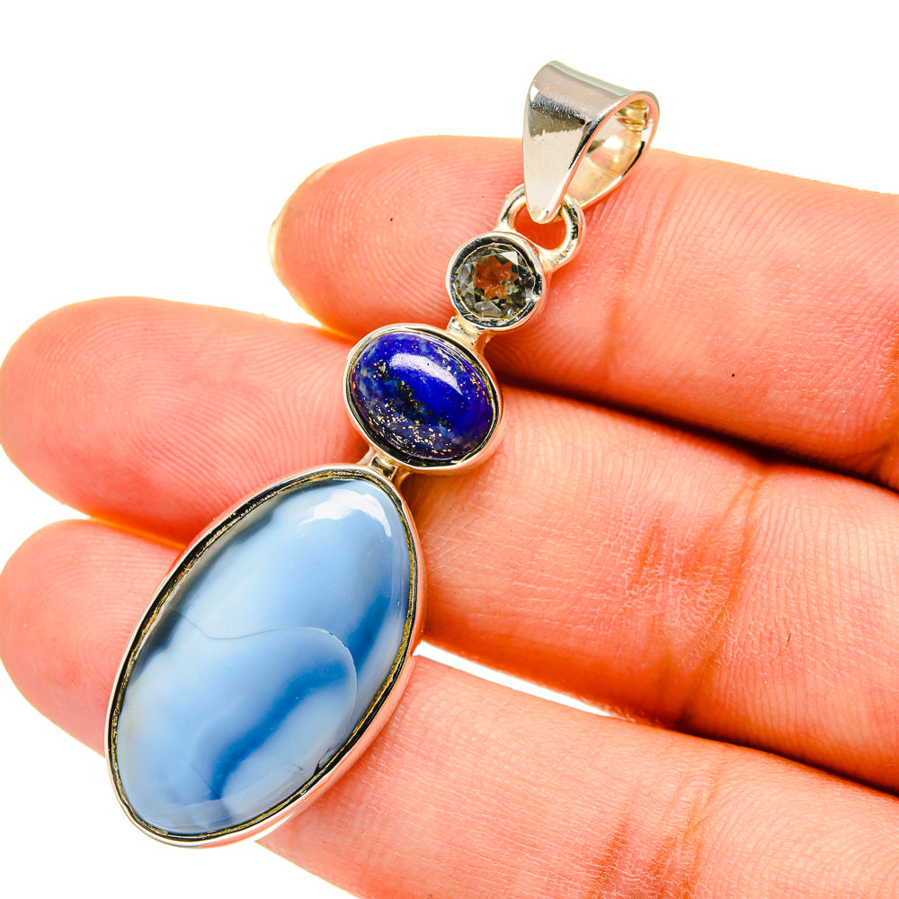 Oval sky-blue pendant with gold-tone bezel, dark-blue round stone and clear accent