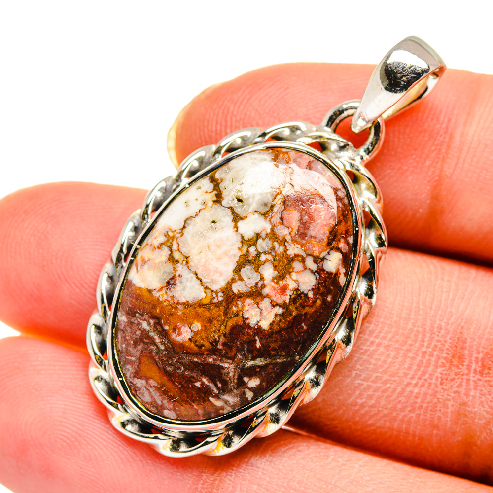 Oval marbled gemstone pendant in silver bezel with dark brown, cream, and red stone