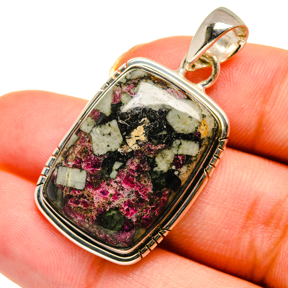 Silver eudialyte pendant with rectangular bezel-set stone, pink, black, and green speckles.