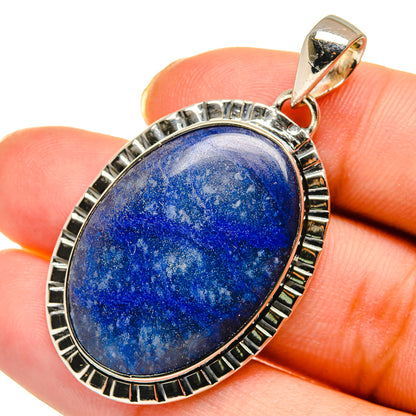 Sodalite stone pendant close-up: oval blue cabochon with ridged silver bezel and bail