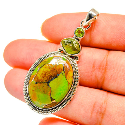 Oval green gemstone pendant with silver-tone bezel and loop bail, small peridot accents