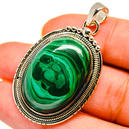 Oval green malachite cabochon pendant in sterling silver bezel with bail